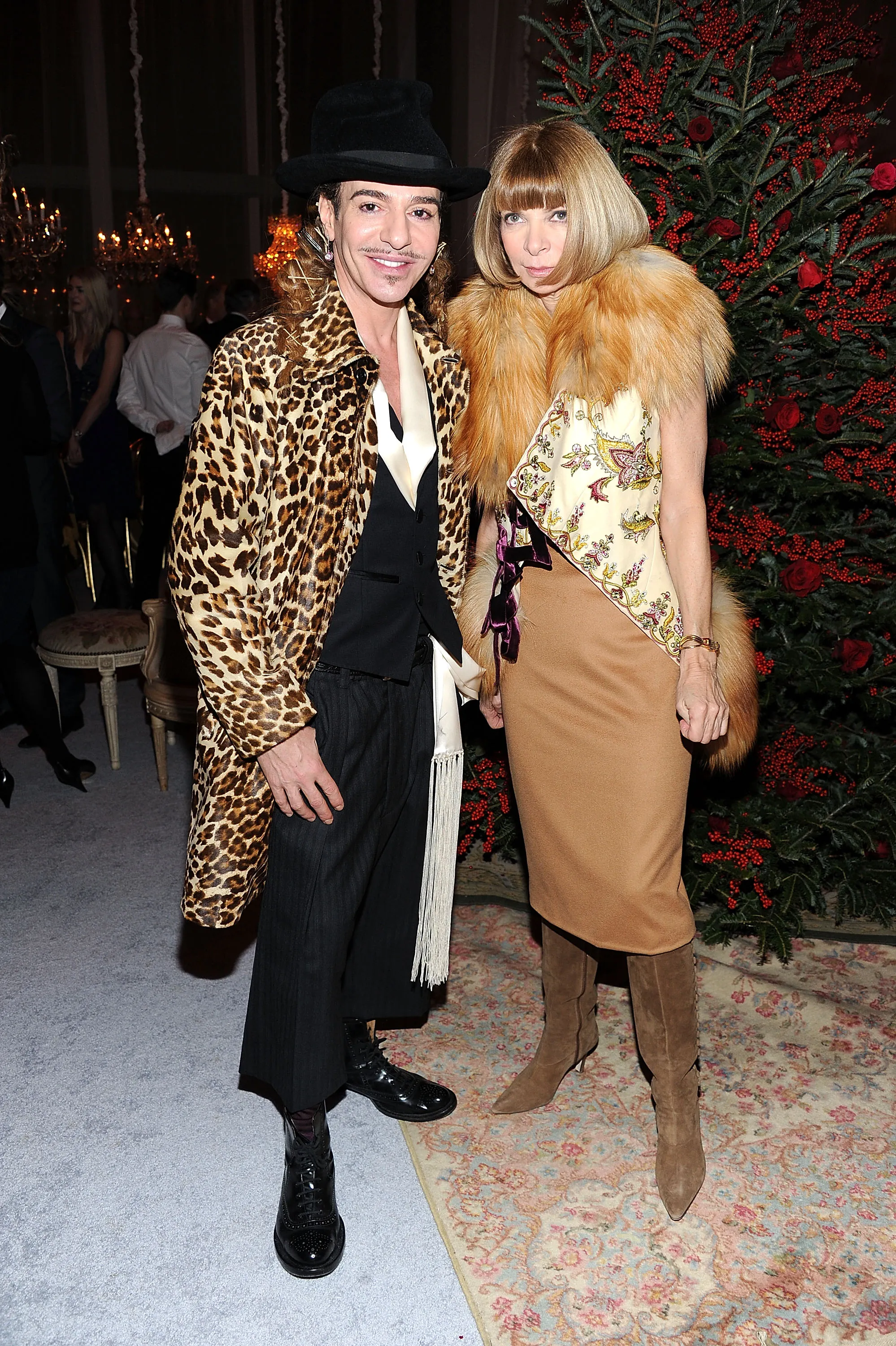 Designer John Galliano and Anna Wintour stand together at an event.