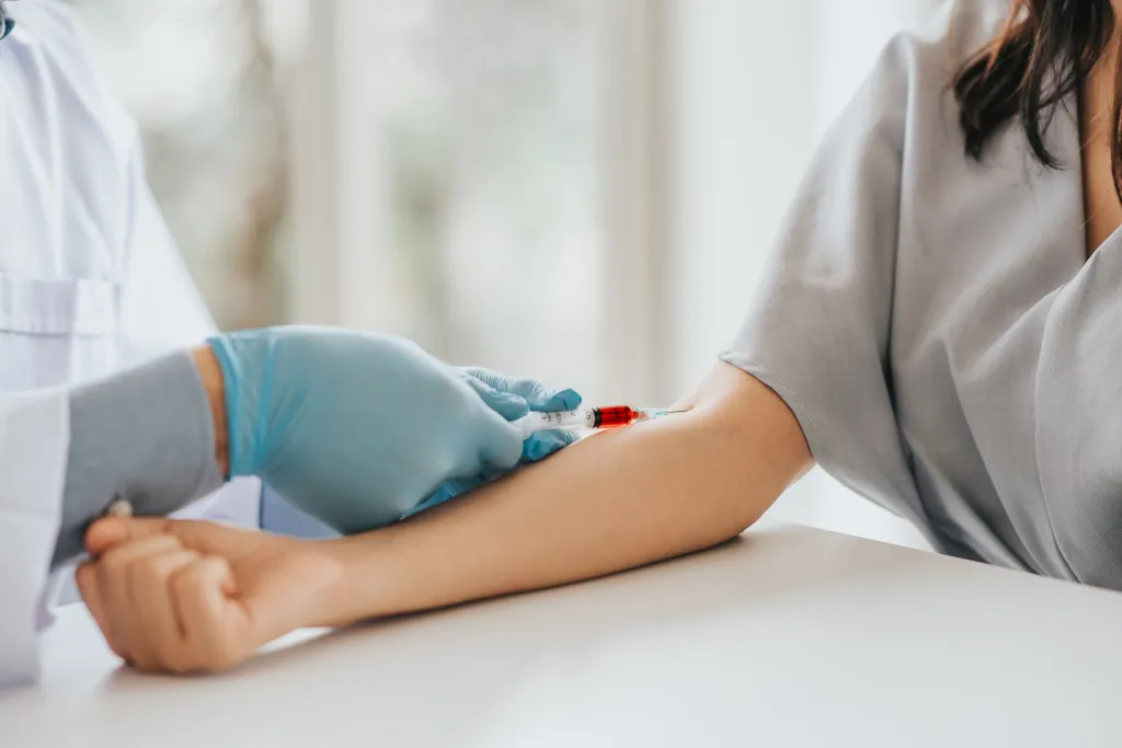 A medical professional drawing blood from a patient's arm.