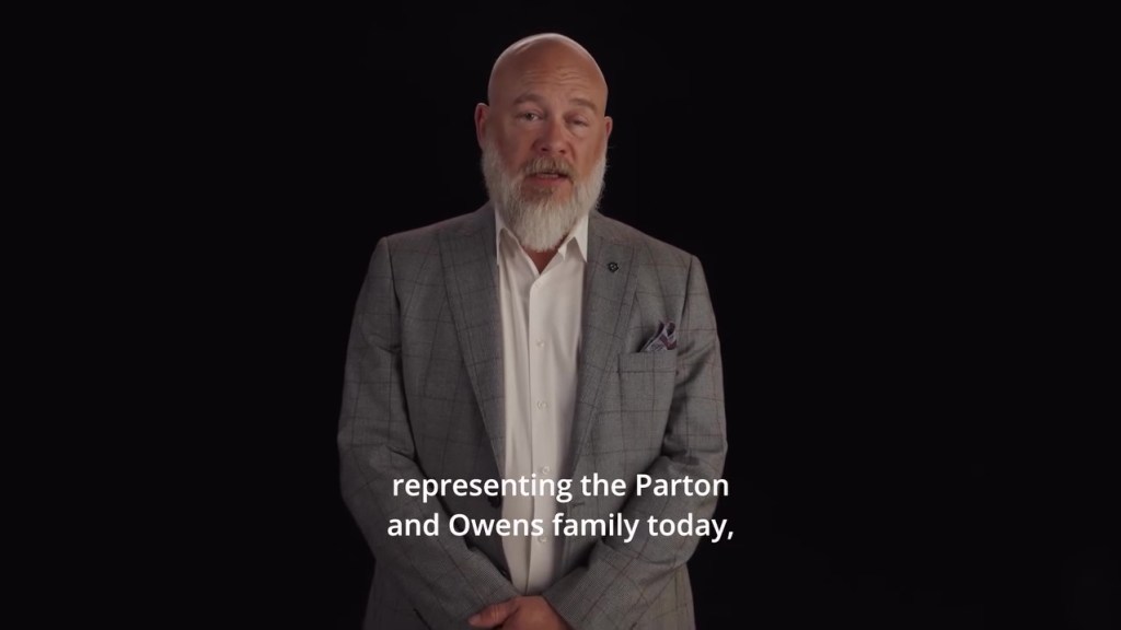 Dolly Parton's nephew, Bryan Seaver, standing against a dark background.