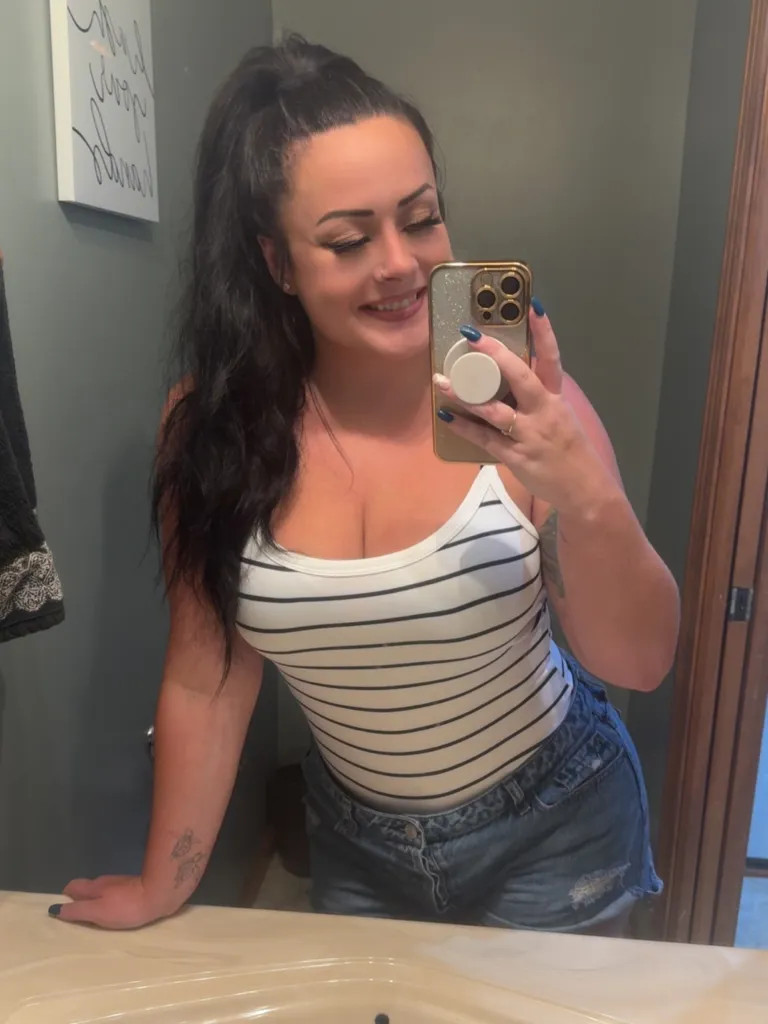 Megan Gaither smiling and taking a mirror selfie.