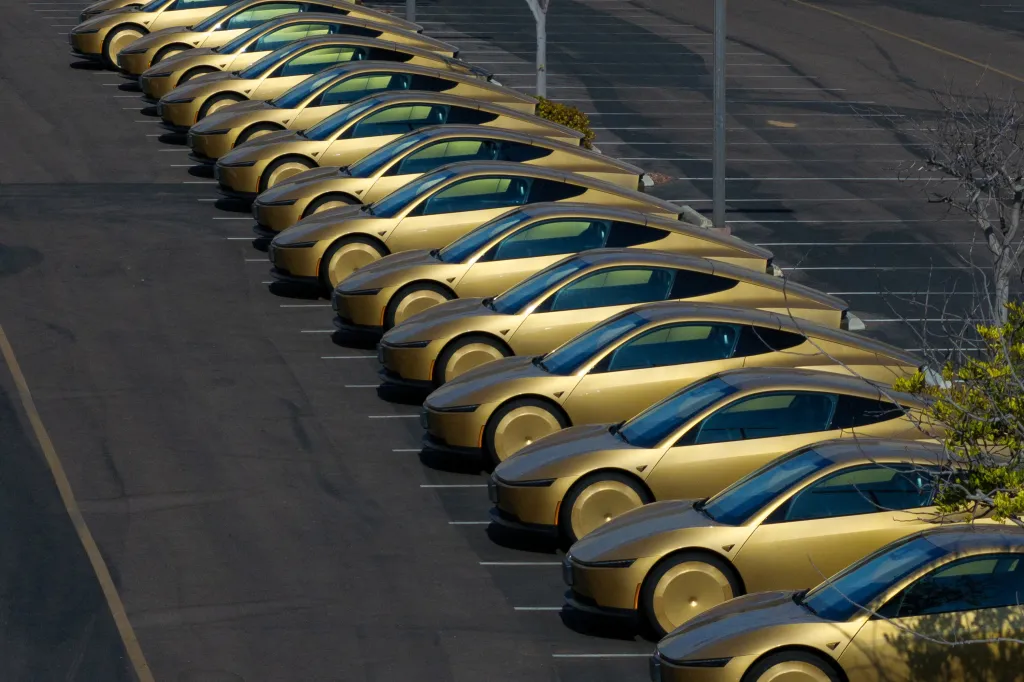 Gold Tesla Cybercabs lined up in a parking lot.