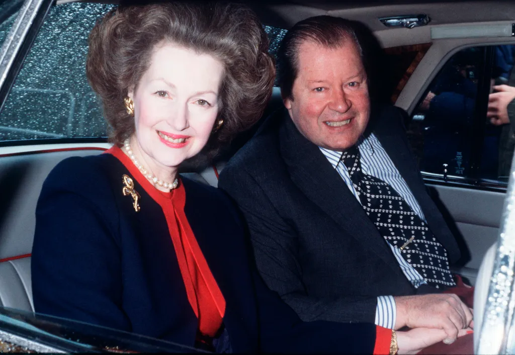 Earl Spencer and Raine Spencer smiling and holding hands in a car.