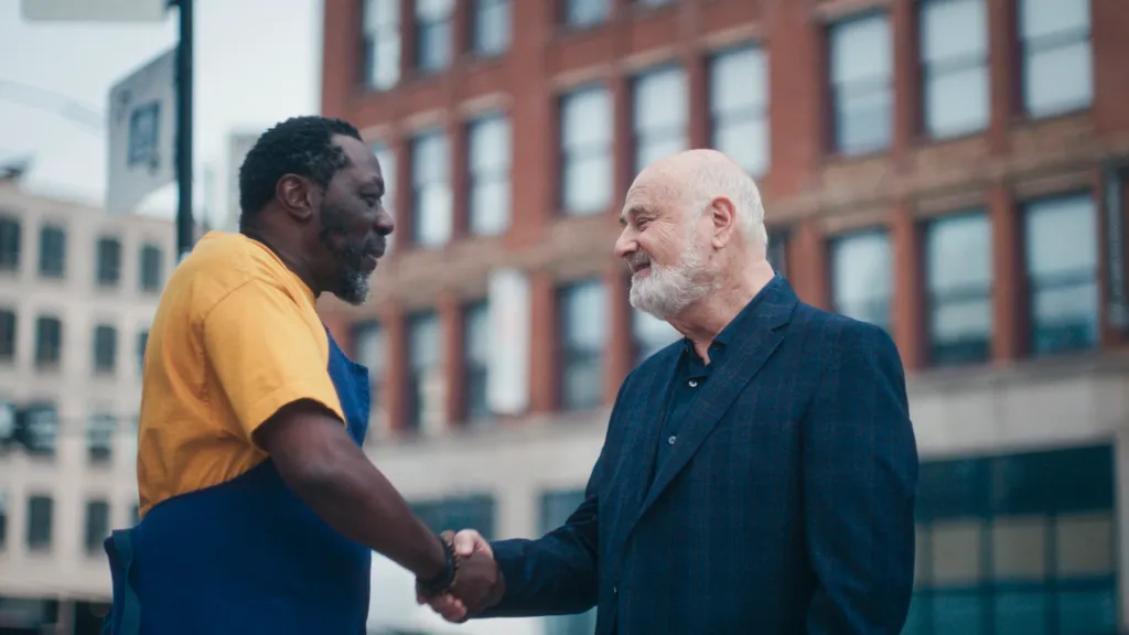 Edwin Lee Gibson and Rob Reiner shaking hands.