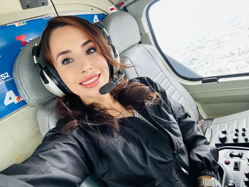 Eliana Moreno, NBC4 reporter, wearing a headset with a microphone in a helicopter cockpit.