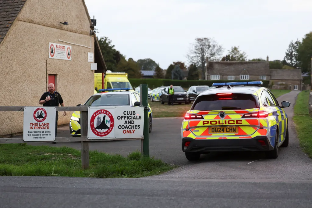 Emergency vehicles, including a police car and an ambulance, are parked at Fairford Youth Football Club.