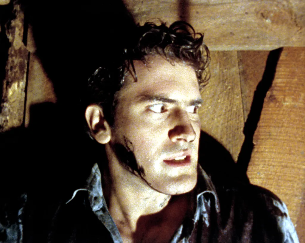 Bruce Campbell as Ash Williams with a horrified expression in Evil Dead.