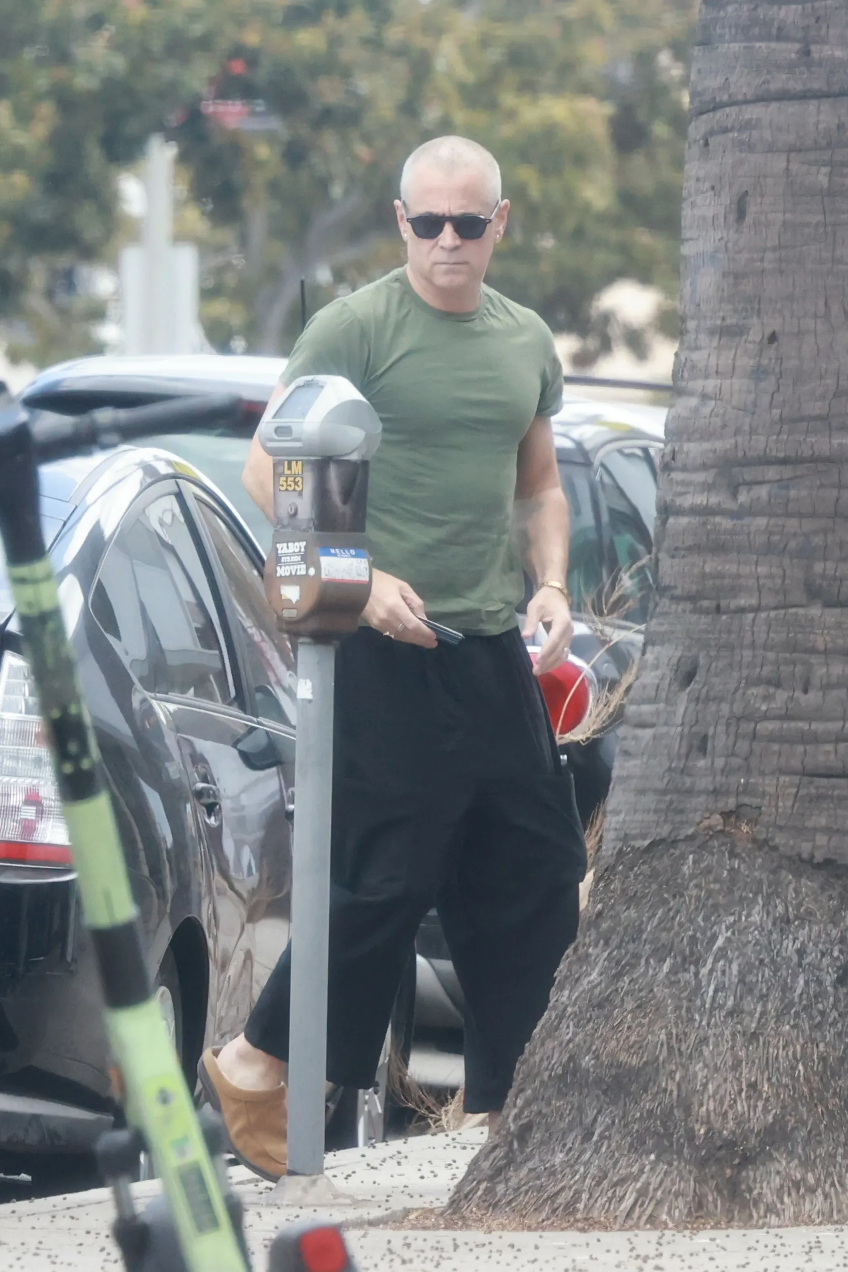 Colin Farrell sporting a newly shaved head and sunglasses.