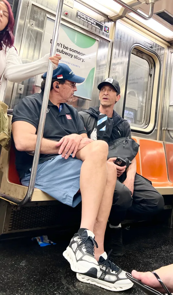 Adrien Brody riding the New York City subway with a friend.