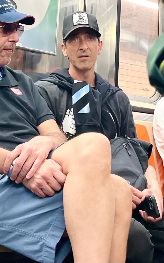 Adrien Brody riding the New York City subway with a friend.