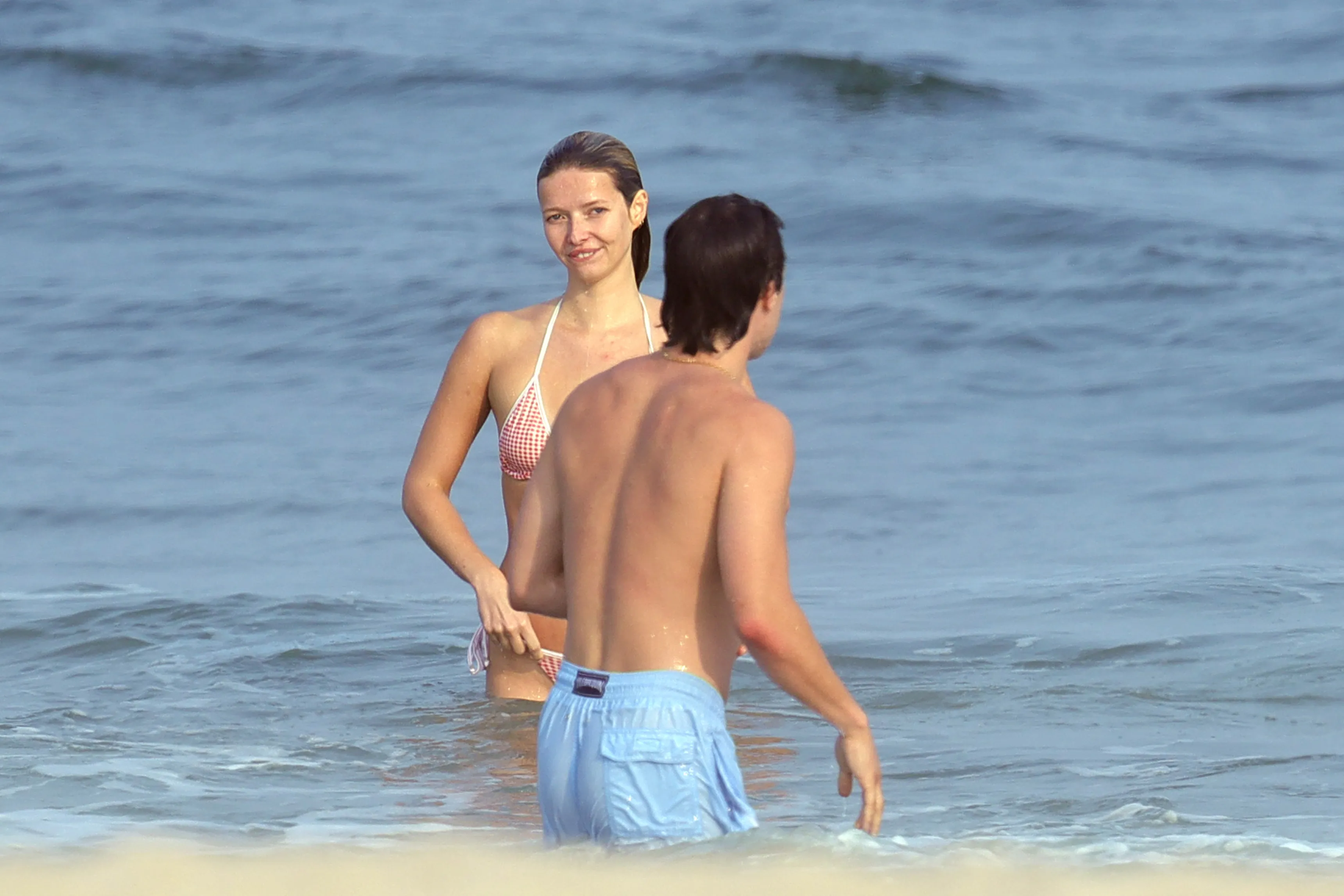 Apple Martin in a gingham bikini with a mystery man in the Hamptons.