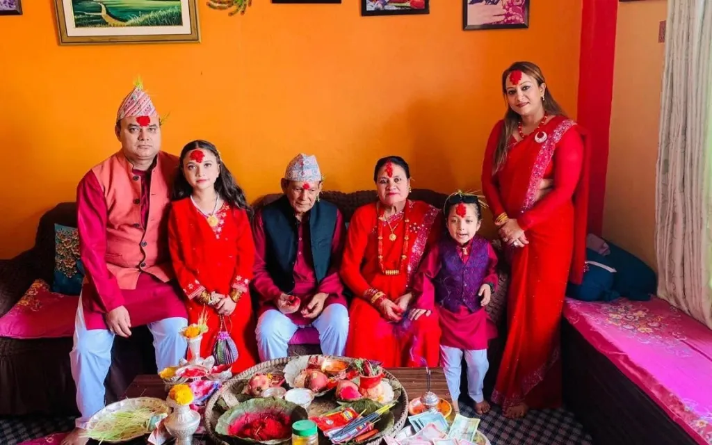 Laxmi Pandey Pyakurel with her family in Nepal, celebrating and wearing red.