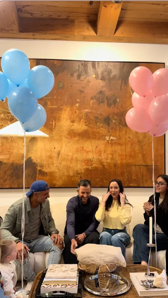 Farrah Brittany and Zach Goldsmith at a baby gender reveal with pink and blue balloons.