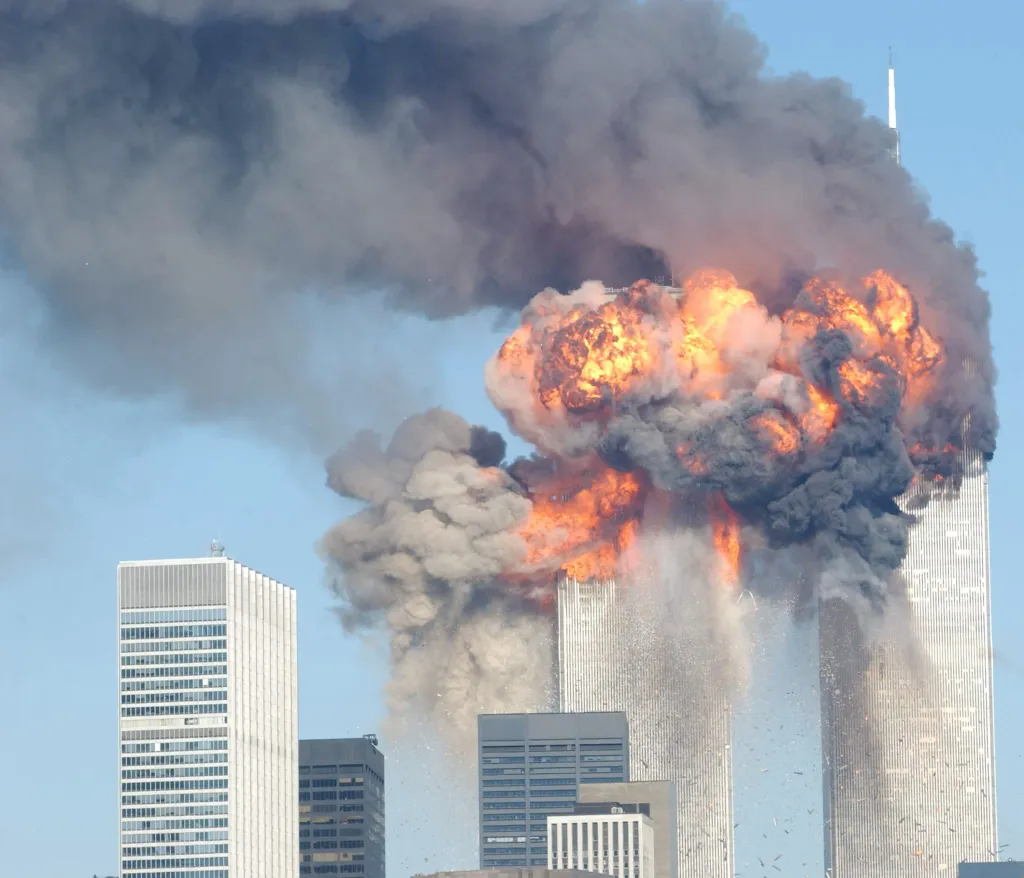 The World Trade Center building engulfed in a fiery blast, with smoke pouring out of the building.
