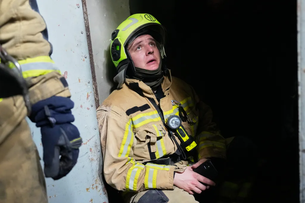 A firefighter in Kyiv hides in a shelter, listening for drones during an air attack.