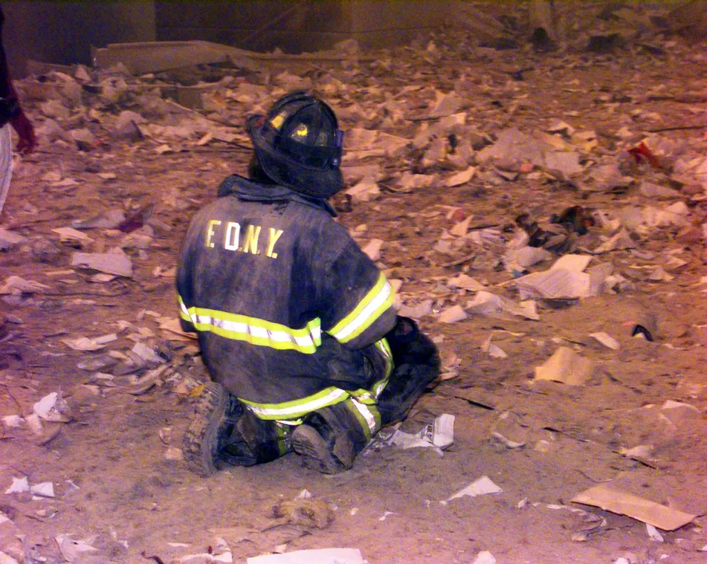 A firefighter prays at Ground Zero at the World Trade Center on Tuesday, Sept. 11, 2001.