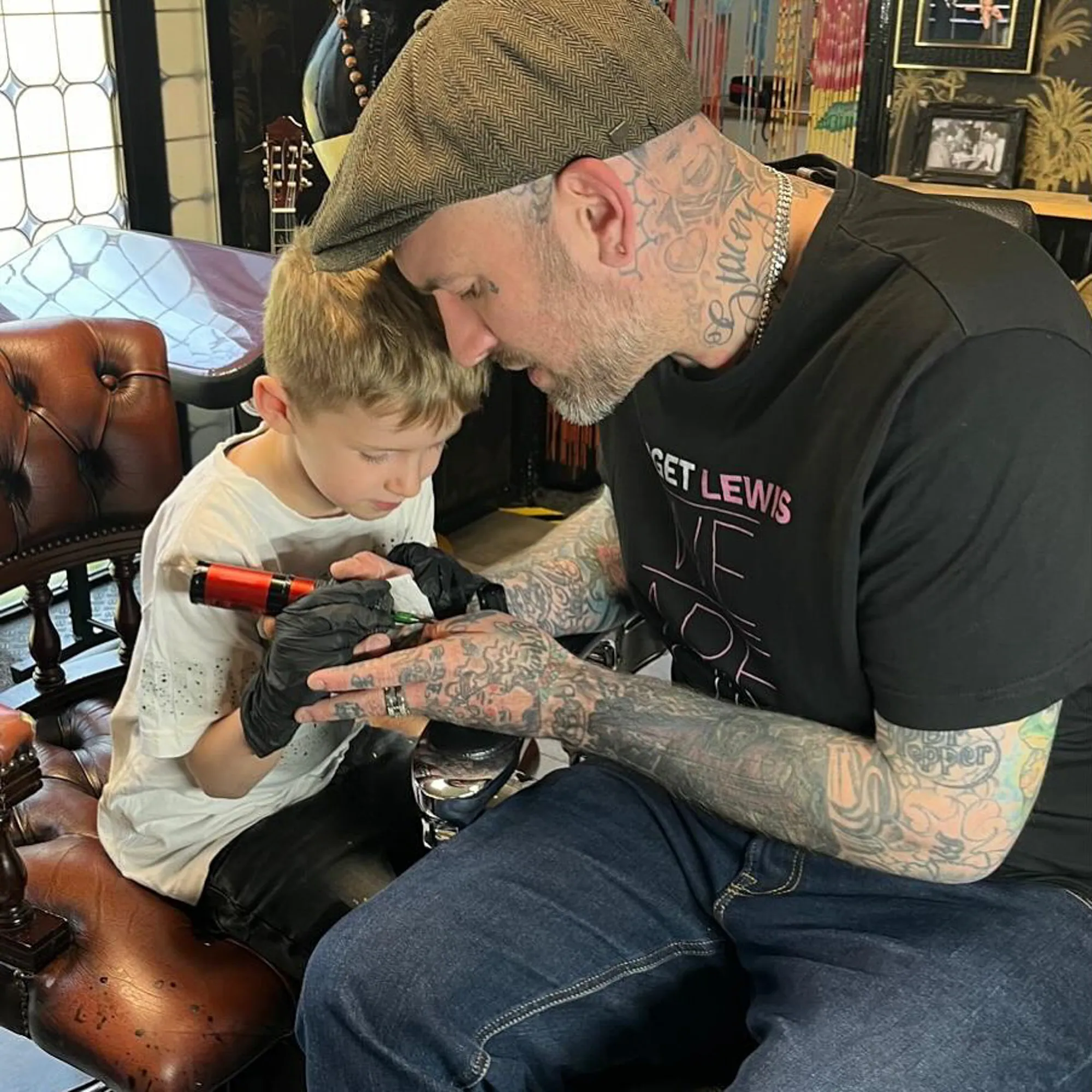 Ben Saunders teaching a child how to use a tattoo gun.