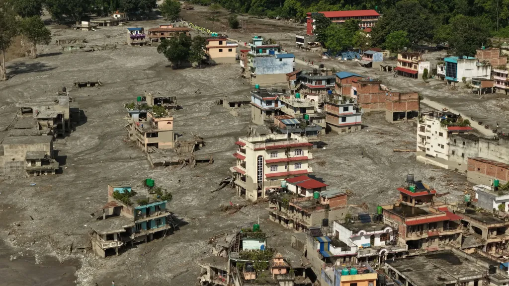 Aerial view of homes partially or completely buried in mud and debris from floods and landslides in Devighat, Nepal.