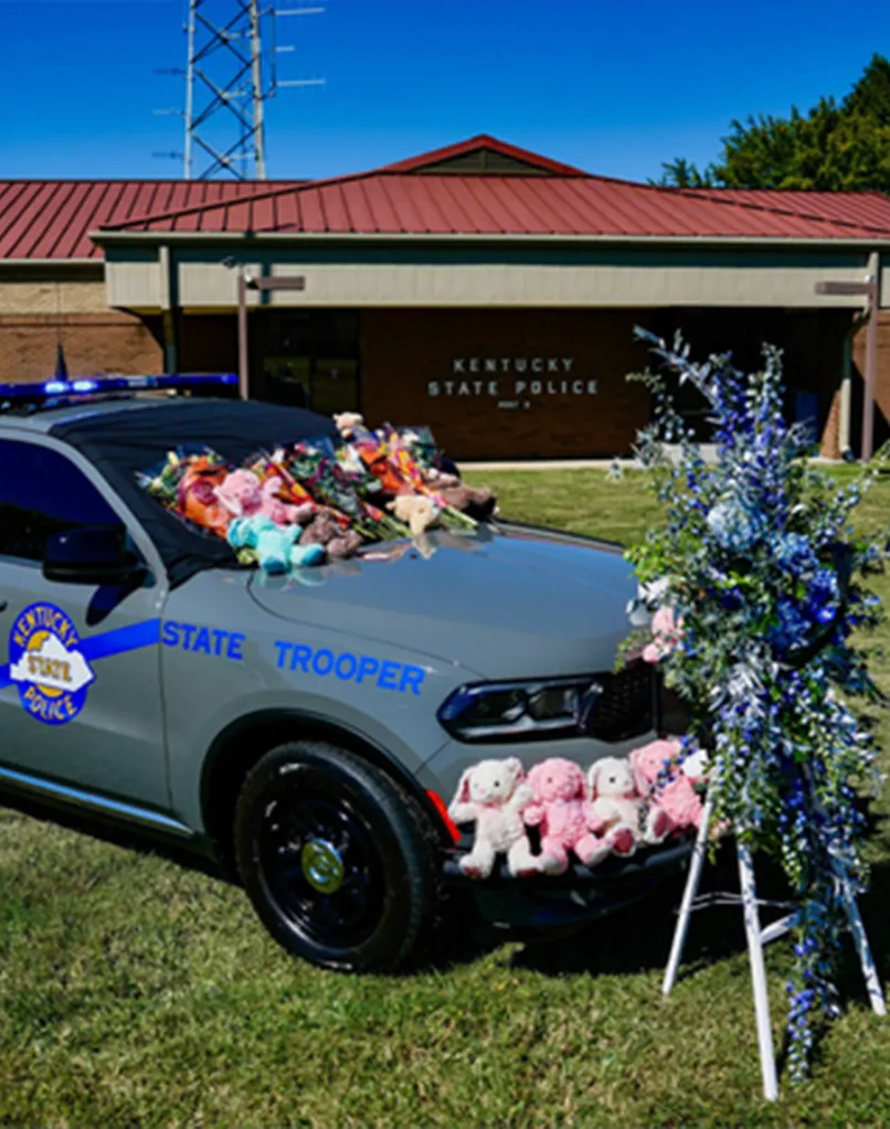 A Kentucky State Trooper cruiser decorated in flowers and stuffed animals in honor of Trooper Hayden Phillips.