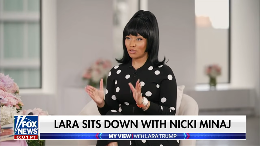 Nicki Minaj in a black polka-dotted dress, being interviewed on Fox News.