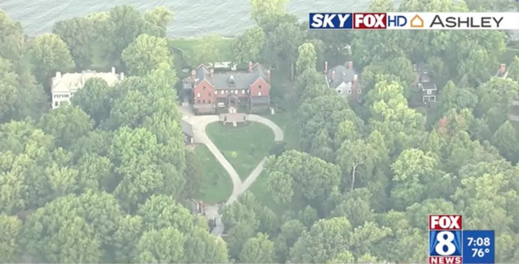 Aerial view of Taylor Swift and Travis Kelce's new home in Ohio, a large red brick house surrounded by trees with a heart-shaped driveway.