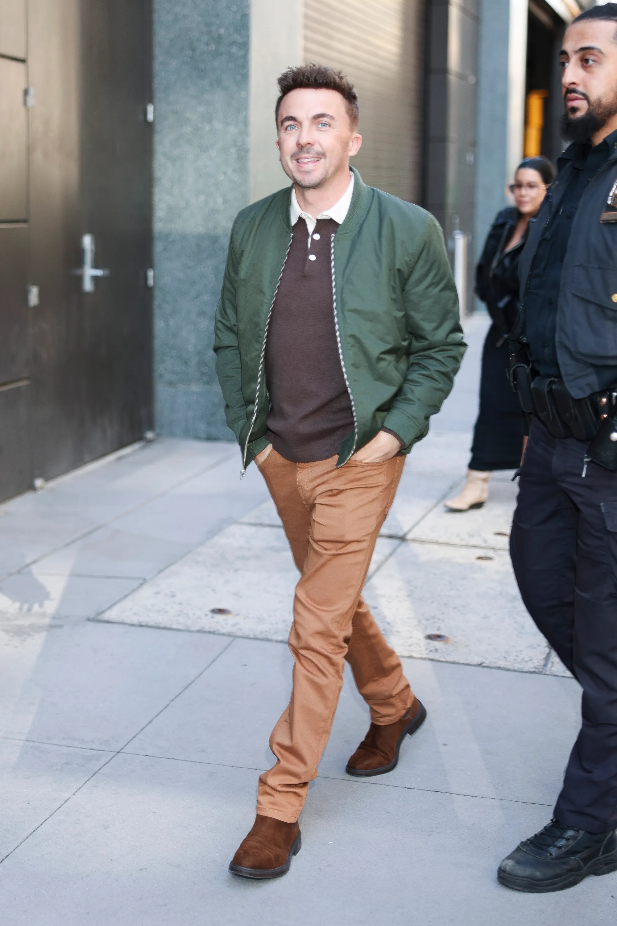 Frankie Muniz walking with hands in pockets in Hudson Square.