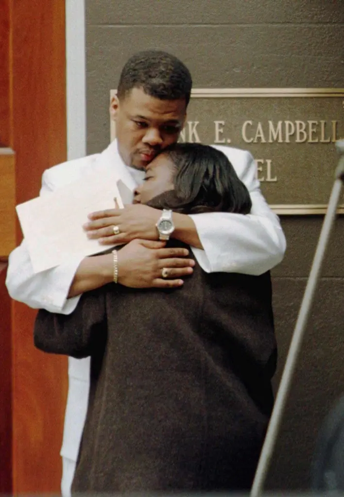 Friends comfort each other at Notorious B.I.G.'s funeral.