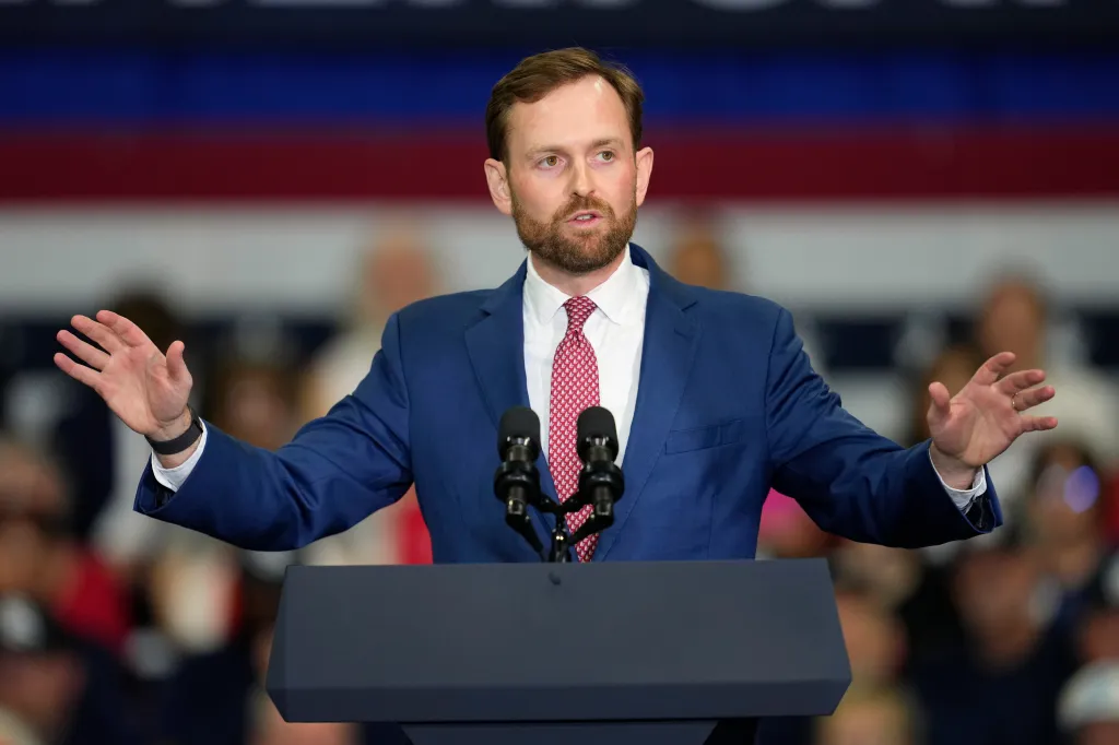 FTC Chairman Andrew Ferguson speaks at a podium, gesturing with both hands.