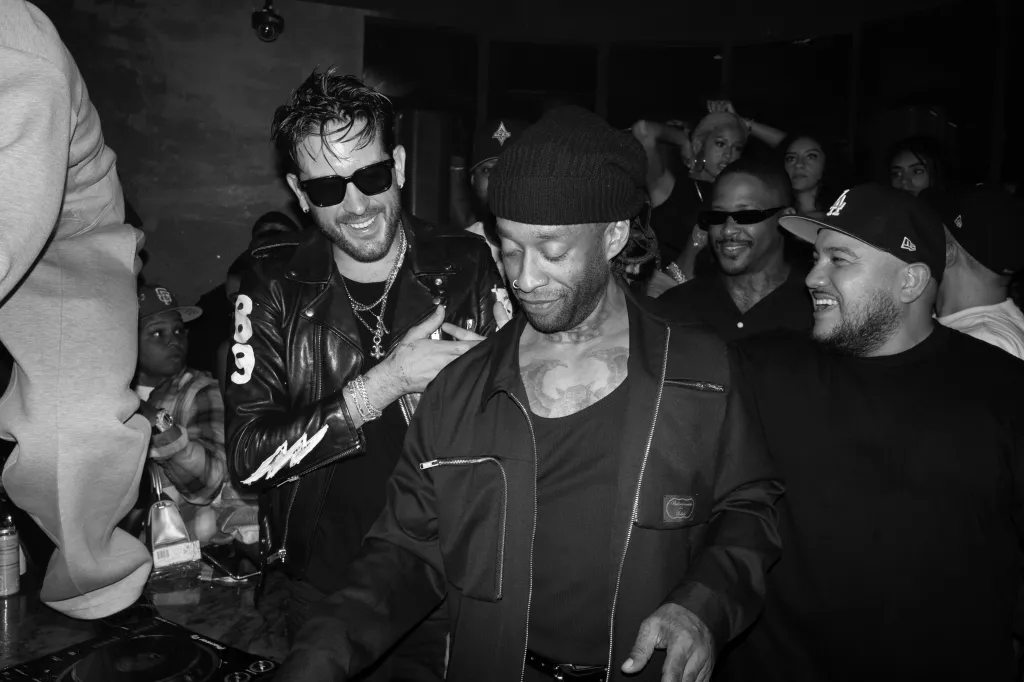 G-Eazy smiling at a club event.