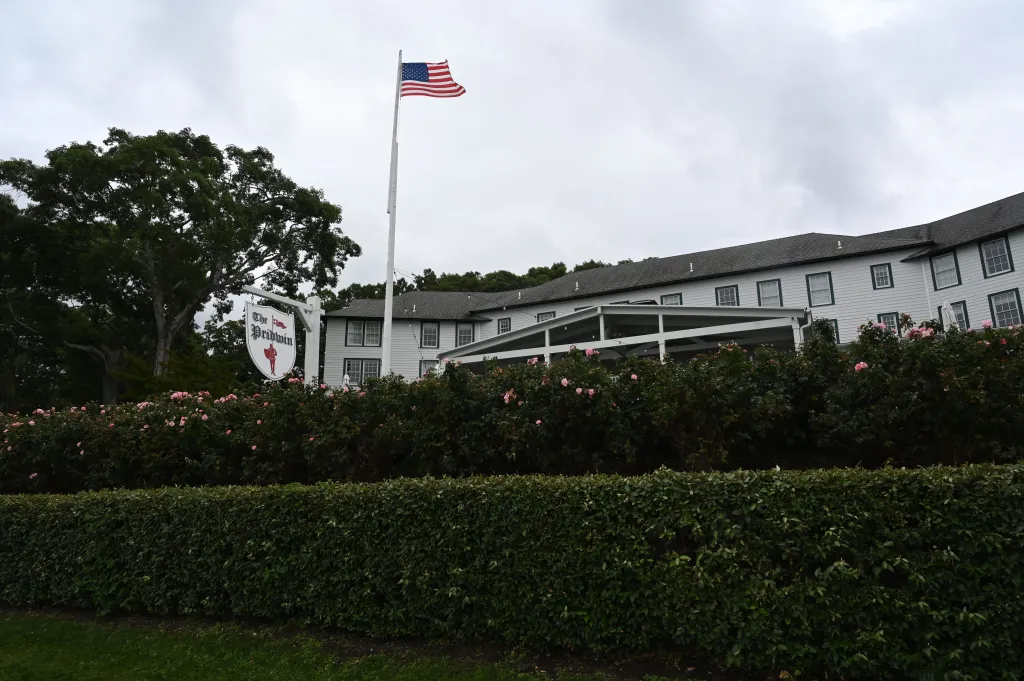 The Pridwin Hotel on Shelter Island, a white building with green trim and a large white sign, with an American flag flying on a pole in front.