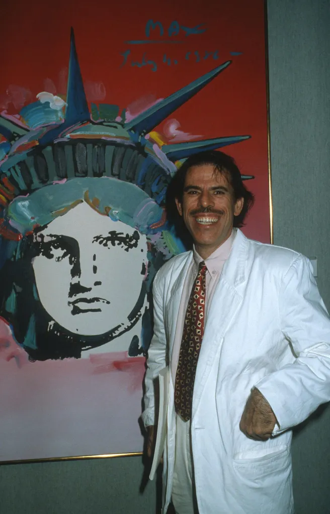 Peter Max, a German-born American Pop artist, stands in front of his art exhibit featuring the Statue of Liberty.