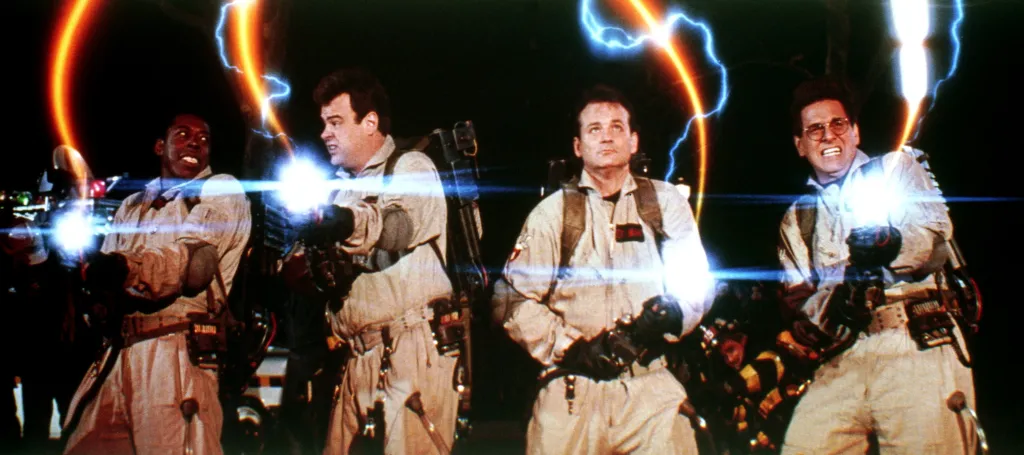 Ernie Hudson, Dan Aykroyd, Bill Murray, and Harold Ramis as the Ghostbusters, firing proton streams.