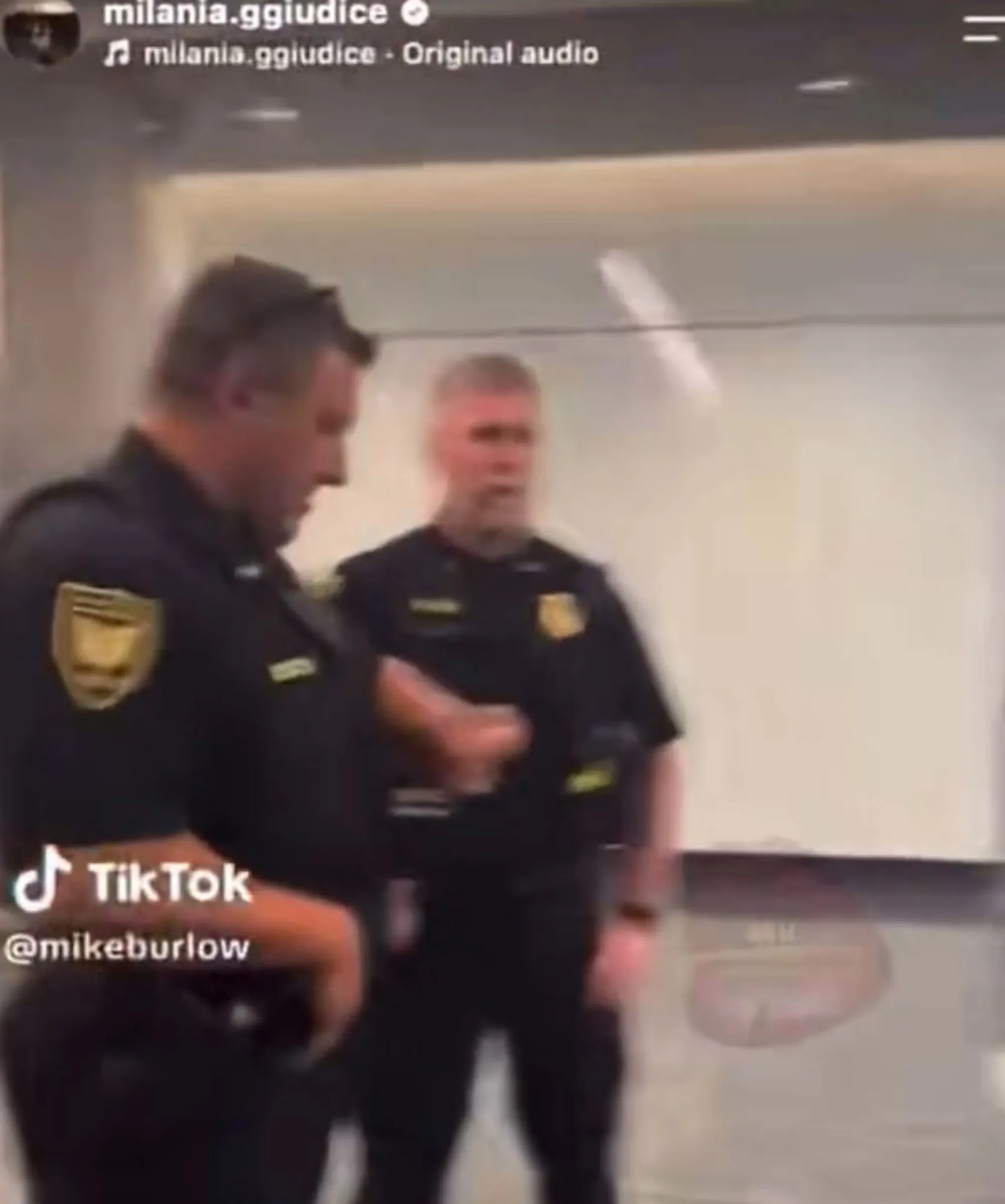 Two police officers standing in a room.