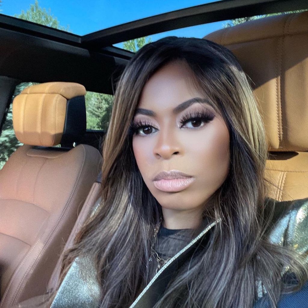 Mary Cosby wearing a black shirt and a silver jacket in a car with brown leather seats and a sunroof.