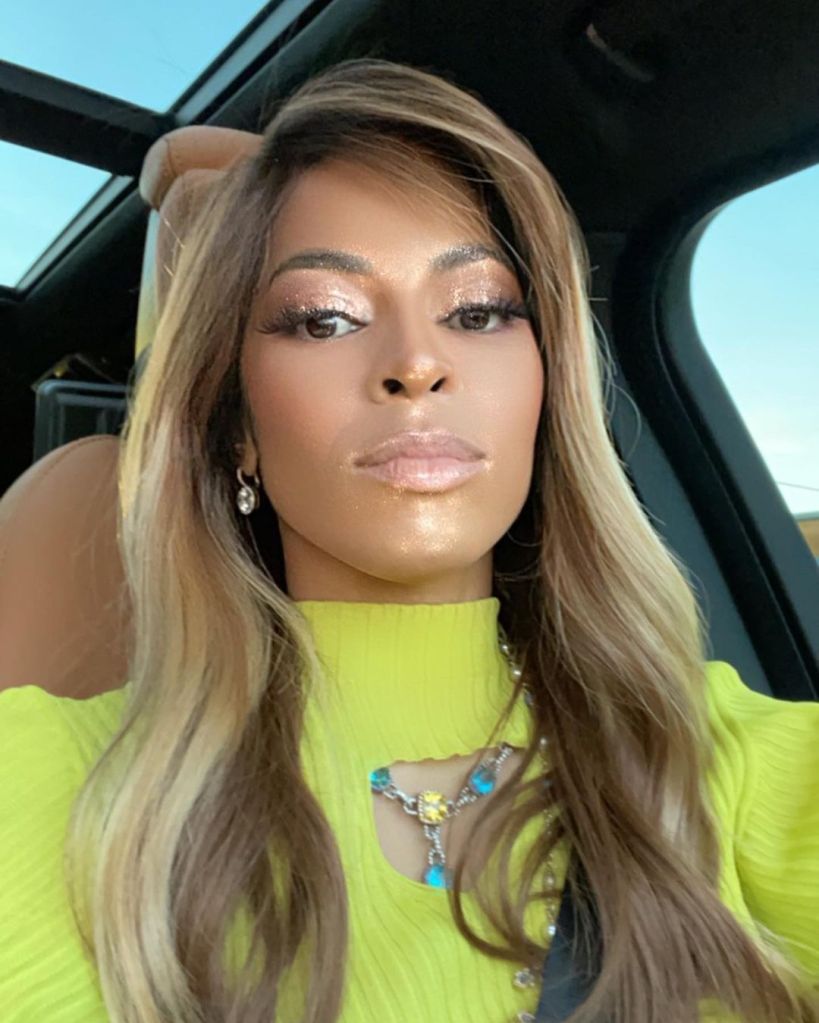 Mary Cosby in a car, wearing a neon green top, with long blonde hair and glittery makeup.