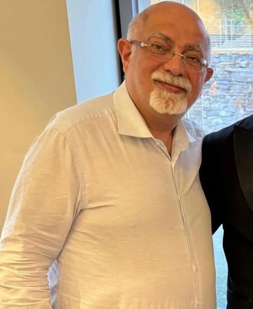 Kamran Hekmati, a man with a white goatee and glasses, in a white collared shirt.