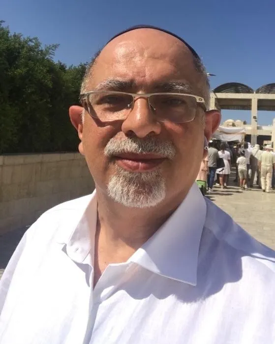 Kamran Hekmati wearing glasses, a white collared shirt, and a yarmulke.