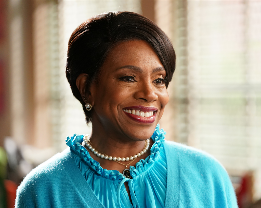 Sheryl Lee Ralph smiling in a blue top and pearl necklace.
