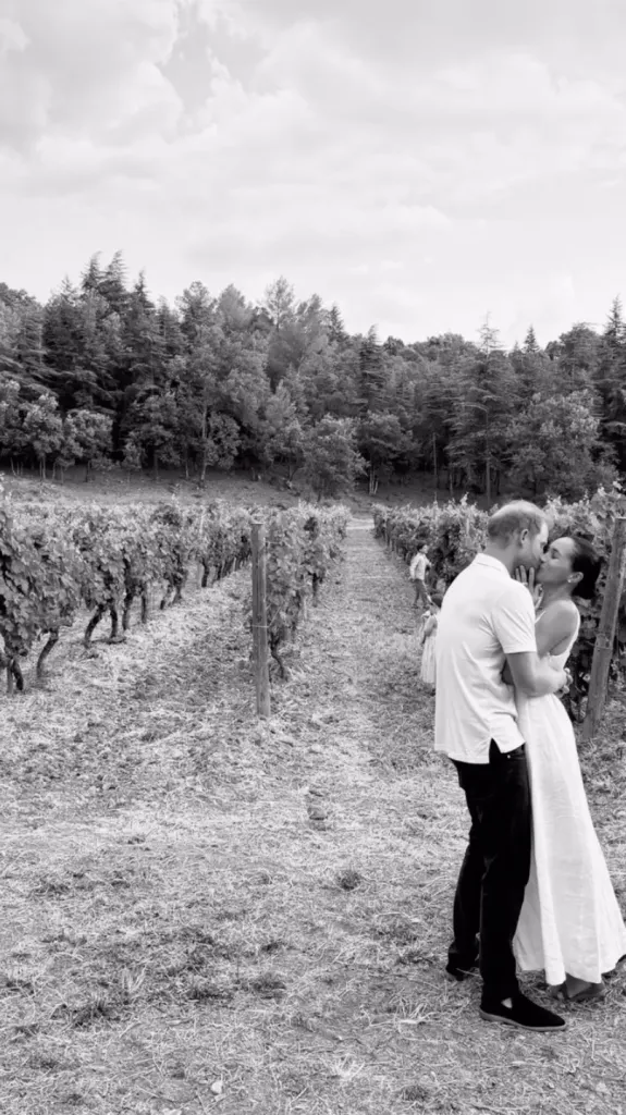 Black and white photo of Prince Harry and Meghan Markle kissing in a vineyard.