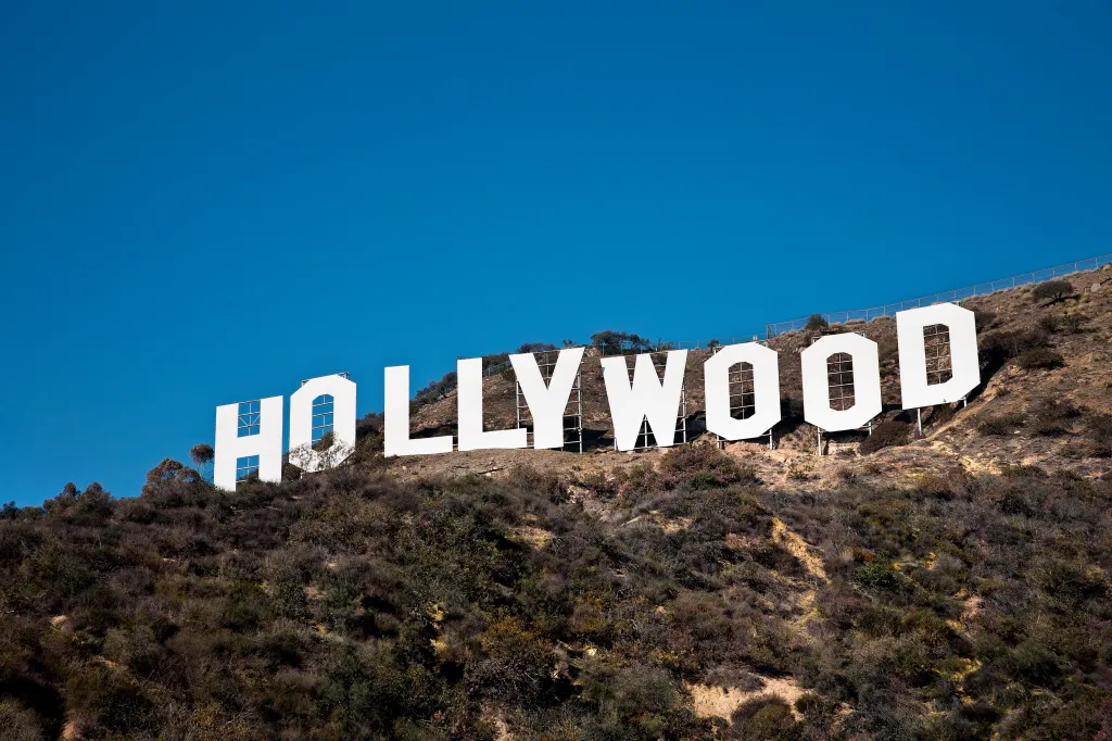 The Hollywood sign on a hillside with a clear blue sky.