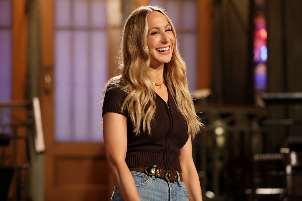 Nikki Glaser smiling and laughing during promos for Saturday Night Live.