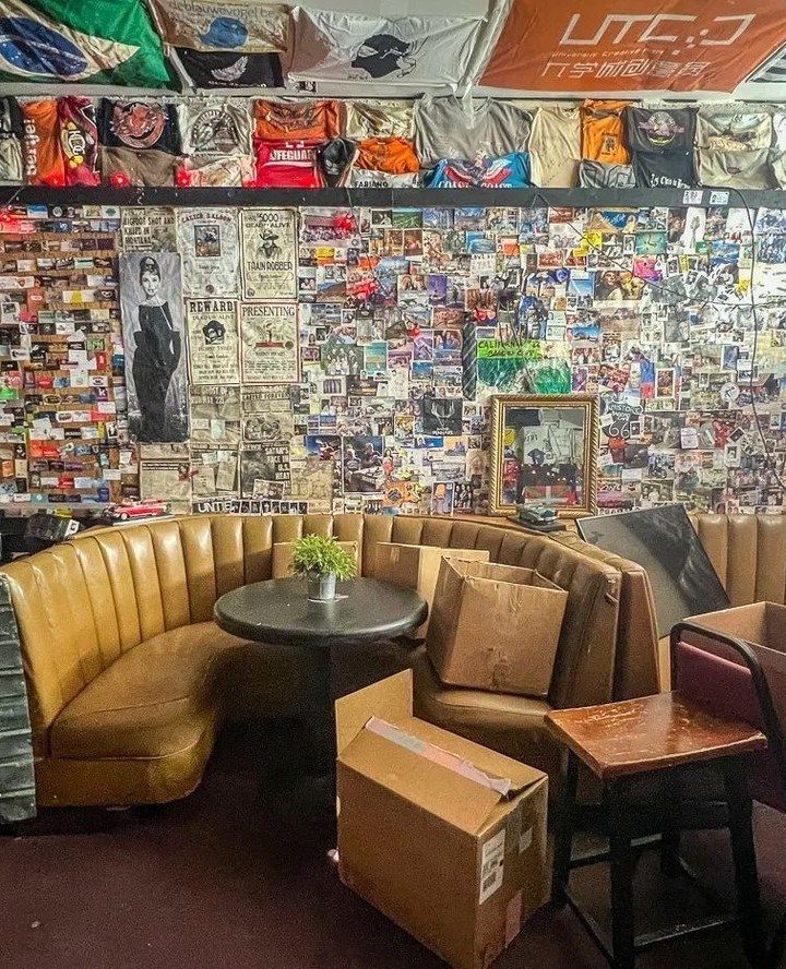 Interior of the Bagdad Cafe, a Route 66 icon, with a wall covered in posters and memorabilia, and a booth with boxes.