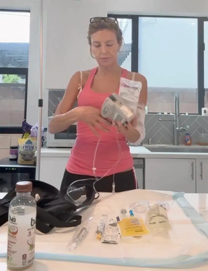 Brandi Glanville setting up an IV infusion with medical supplies laid out on a table.