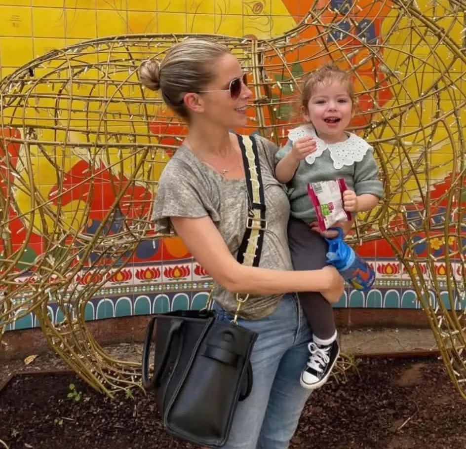 Sienna, who began puberty at 10 months old, held by her mother Sophie.