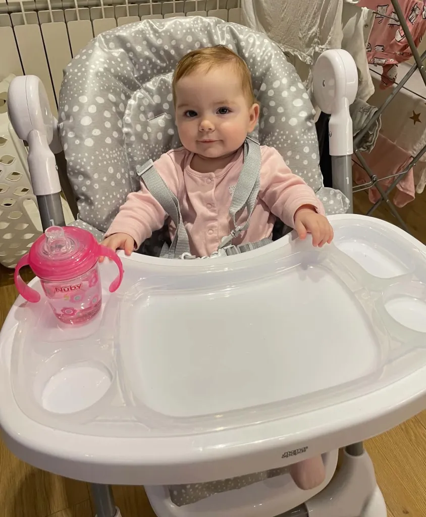 10-month-old Sienna, diagnosed with central precocious puberty, sitting in a high chair.