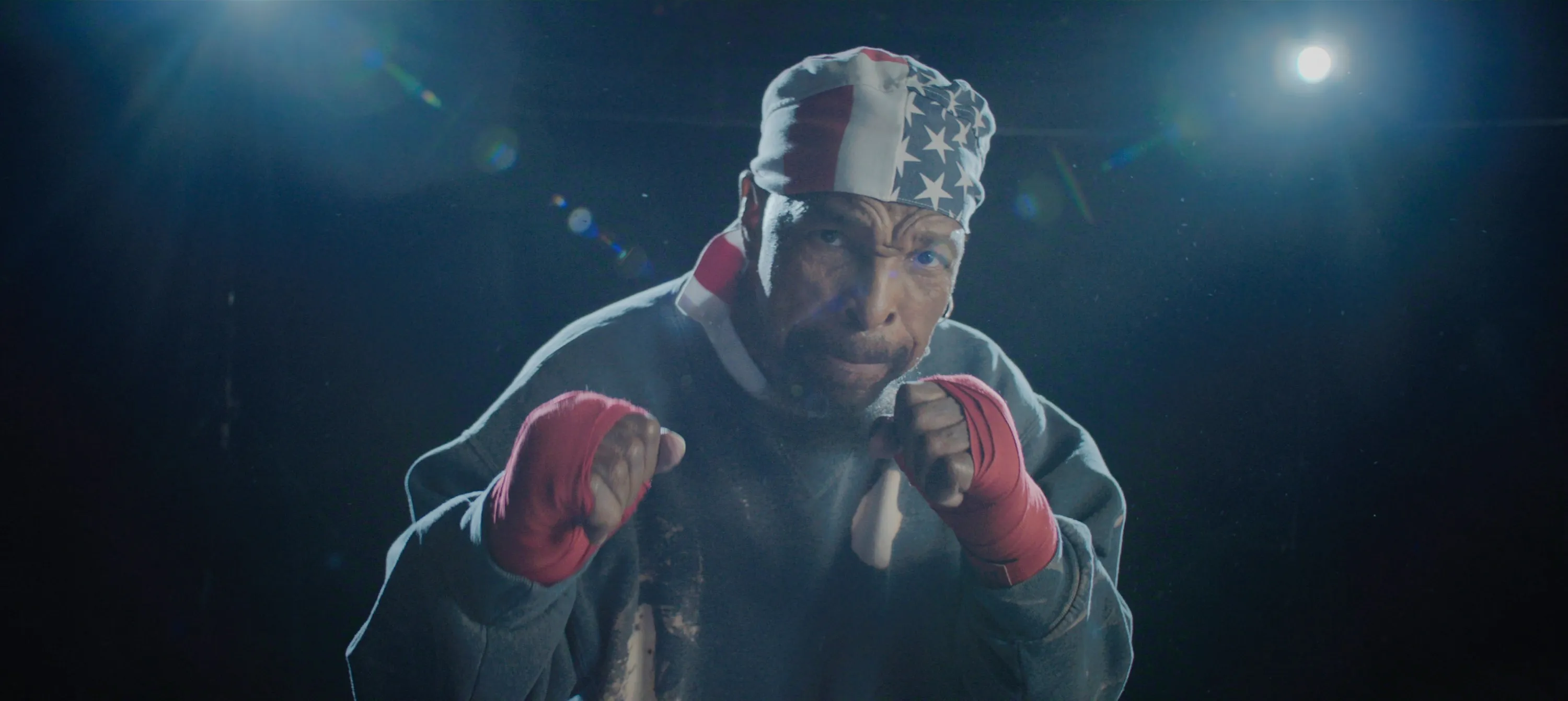 Mr. T in a boxing stance, wearing an American flag bandana and red hand wraps.