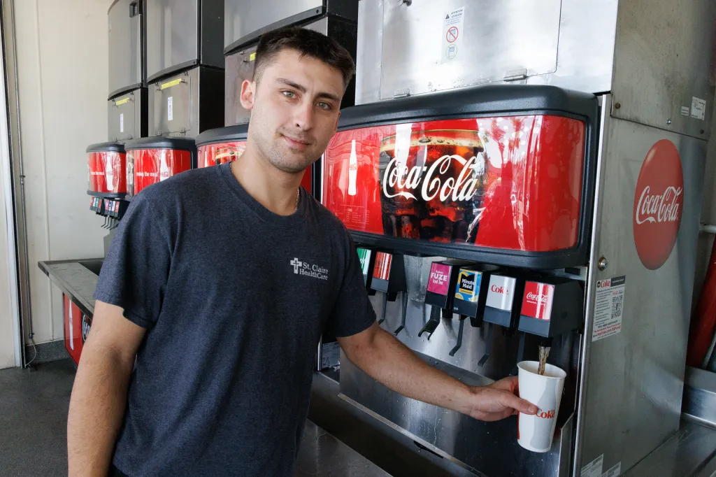 Carter Sakamoto fills a cup with a soda from a fountain dispenser at a restaurant in Los Angeles.