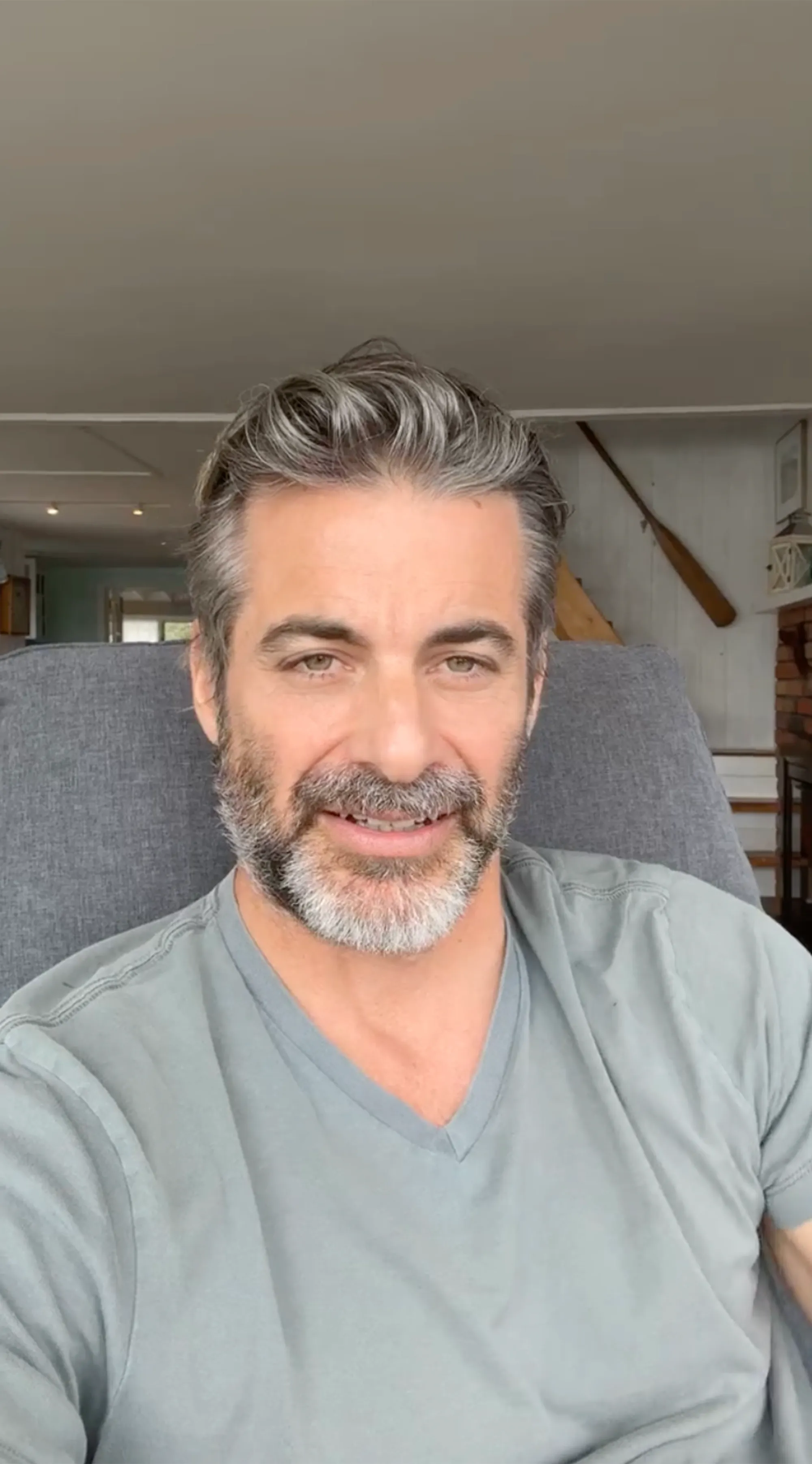Jim Curtis, a white man with graying hair and beard, wearing a light blue V-neck shirt.