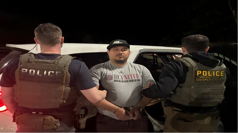 Yinmi Molina-Zepeda, an immigrant from El Salvador, handcuffed between two ICE agents.