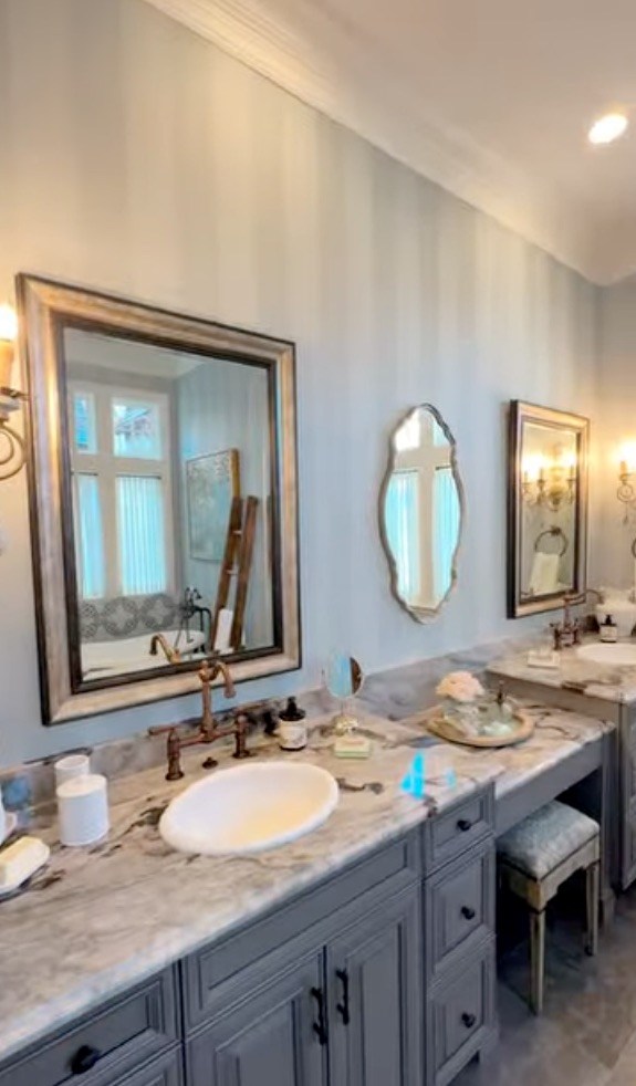 The spacious bathroom features dual sinks, a long stone countertop and understated Disney-inspired detailing.