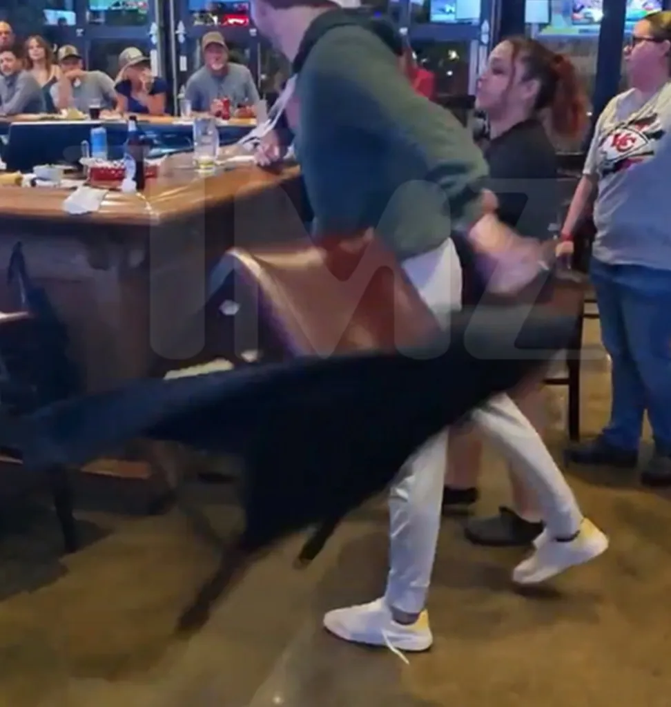 A man flinging a chair at a bar.